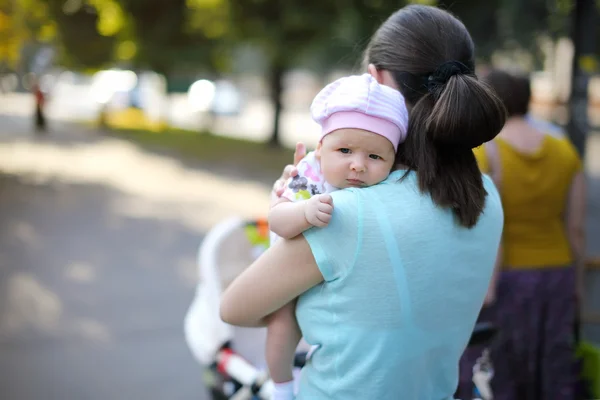 Flickan på axeln på mamma. porträtt — Stockfoto