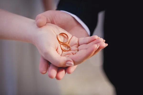 Mani di sposo e sposa con fedi nuziali — Foto Stock