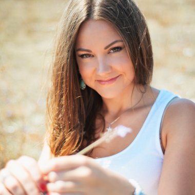 çimenlerin üzerinde oturan güzel genç kadın