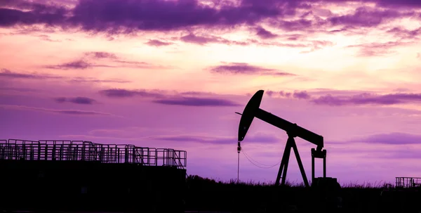 Silueta de bombas de aceite en el campo petrolífero con fondo cielo puesta del sol — Foto de Stock