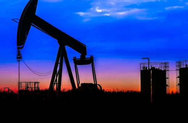 Силуэт нефтяных насосов на нефтяном месторождении на фоне заката — стоковое фото