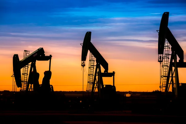 Silhouette von Ölpumpen am Ölfeld mit Sonnenuntergang — Stockfoto