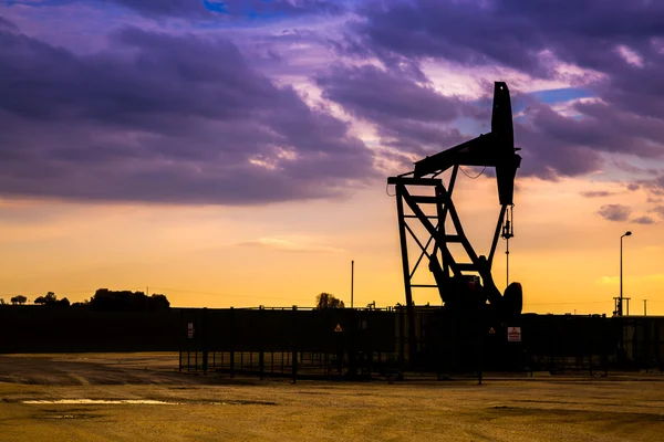 Silueta de bombas de aceite en el campo petrolífero con fondo cielo puesta del sol — Foto de Stock