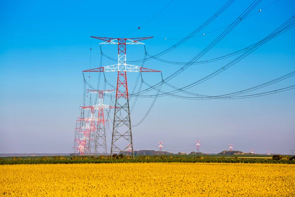 Eletricidade transmissão pilão silhueta contra azul — Fotografia de Stock