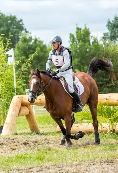 Saint Cyr du Doret, France - July 29, 2016: Horseman riding horse over an obstacle on cross country event — Stock Photo, Image