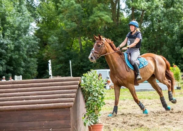 Saint Cyr du Doret, Frankrike - 29 juli 2016: kvinna ridning häst över hinder på cross country händelse — Stockfoto