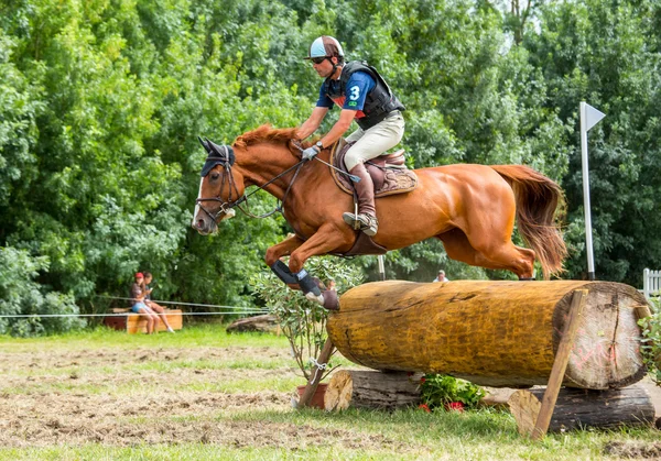 Saint Cyr du Doret, Francia - 29 de julio de 2016: Caballo a caballo por un obstáculo en un evento a campo traviesa — Foto de Stock