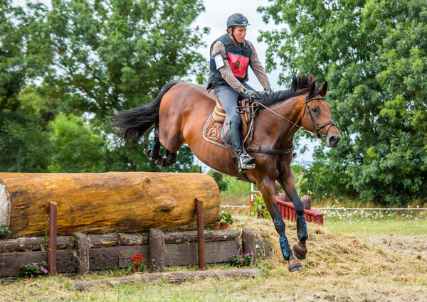 Saint Cyr du Doret, France - July 29, 2016: Horseman riding horse over an obstacle on cross country event