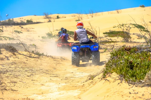 Due quad che corrono uno dietro l'altro in aree deserte polverose — Foto Stock