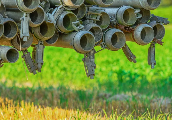 Metallic tubes being transported through the field — Stock Photo, Image