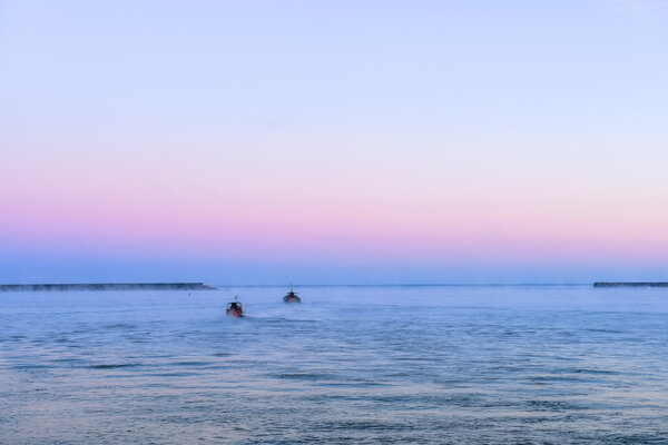 Два корабля направляются к горизонту в открытом море
