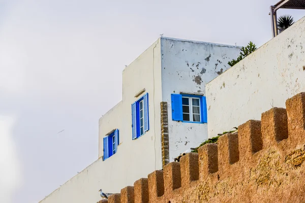 Un alto edificio blanco rodeado por una puerta de ladrillo estilo almenada —  Fotos de Stock