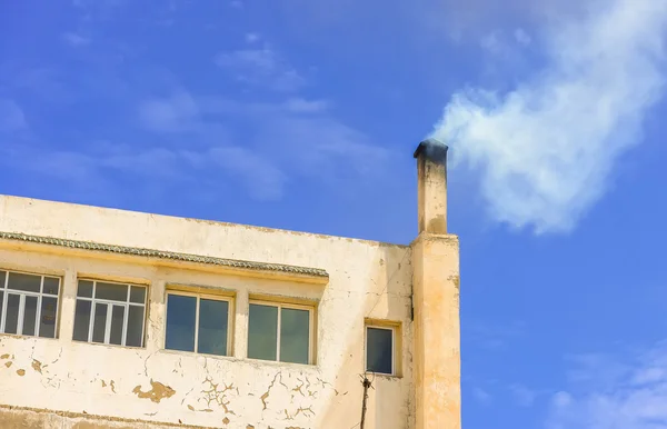 Верхний этаж здания с измоком, выходящим из дымохода — стоковое фото