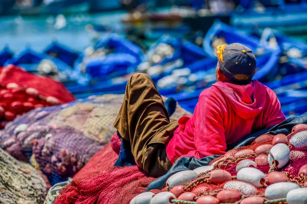 Un uomo che cuce reti da pesca — Foto Stock