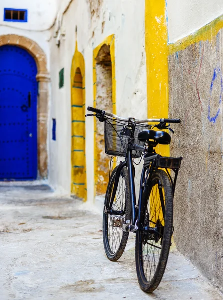 A bicycle leaning to a colorful wall in downtown — Stock Photo, Image