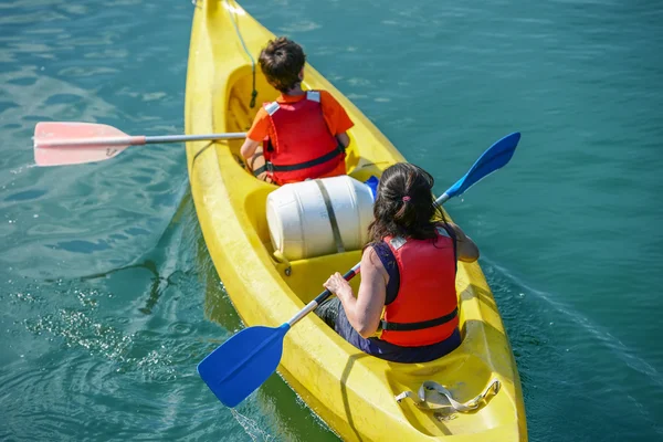 Upper shot of two young people canoeing in the lake — Stock Photo, Image