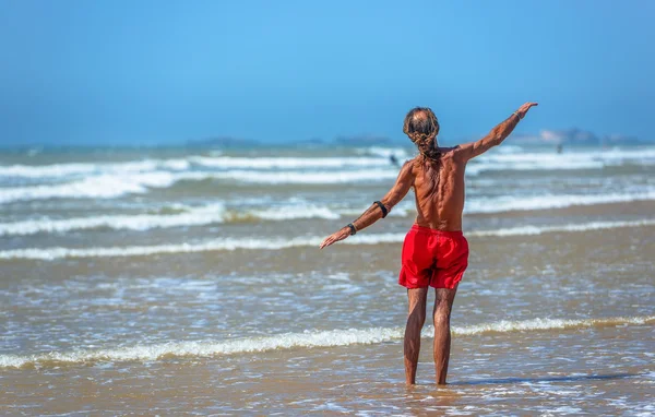 Un bătrân înotător în picioare în valurile mării cu brațele întinse în jurul — Fotografie, imagine de stoc