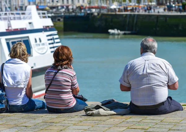 Un homme âgé et deux jeunes femmes admirant le paysage marin — Photo