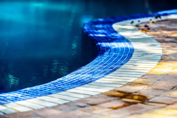 A curvy line of blue and while tiles circling the swimming pool — Stock Photo, Image