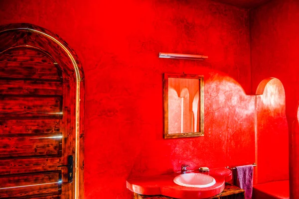 Badezimmer in rotem Muster mit großer Holztür — Stockfoto