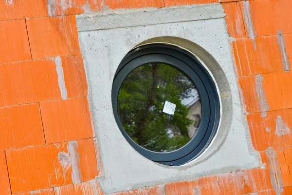 Ventana redonda en una pared de ladrillo — Foto de Stock