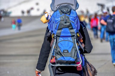 Closeup sırtında bir bebek taşıyan kadın için