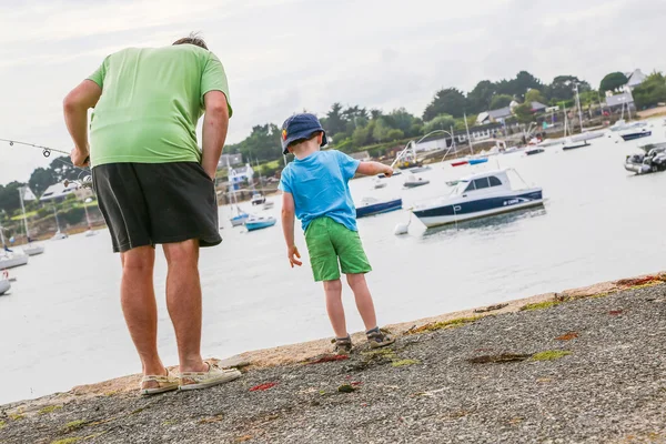 A little boy fishing together with his father — Stock Photo, Image