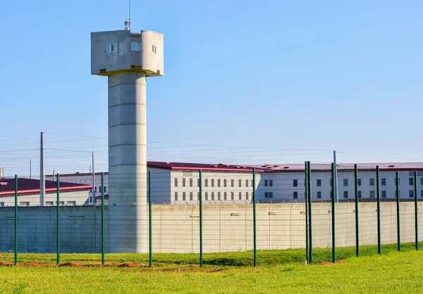 Prison area with a tall watchtower surrounded with fence — Stock Photo, Image