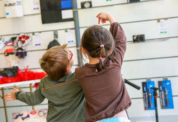 Zwei Kinder betrachten die Produkte in einem Geschäft — Stockfoto