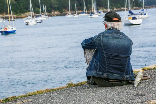 Harbor'da oturan yaşlı bir adam — Stok fotoğraf