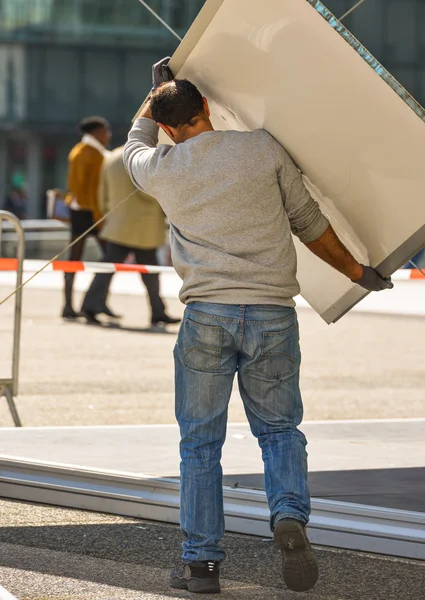 En man som bär en stor styrelse med folie inramning — Stockfoto