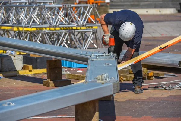 A construction worker drilling halls in metal piece — Stock Photo, Image