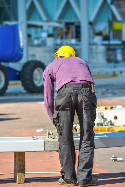 紫のブラウスと建設に取り組んでいる黄色のヘルメットの男 — ストック写真