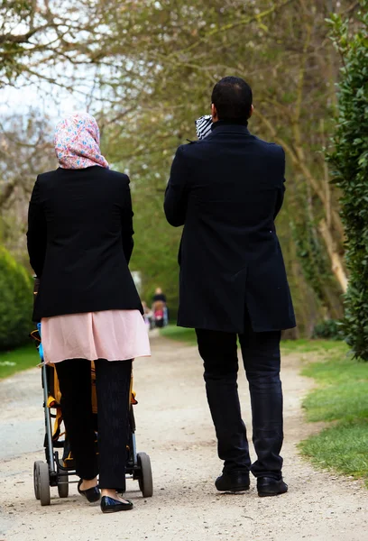 Pareja musulmana caminando con sus hijos en un cochecito —  Fotos de Stock