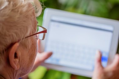 Paris, Fev 2016 - Tablet kullanan yaşlı kadın, kapalı