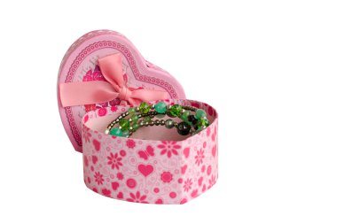 Pembe yay ve açık kapaklı karton kutu beyaz arka planda izole edilmiş. Kutuda bir kolye var..