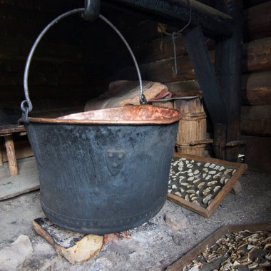 Bir şenlik ateşinin yanan köşelerinde büyük bir bakır kap asılı duruyor. Dağlarda çobanlar tarafından eski yöntemlerle peynir pişirmek. Porcini mantarlarını doğal bir şekilde ateşin etrafında kurutmak..