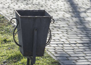 Parktaki demir çöp tenekesi. Parktaki sokakta çöp tenekesi.