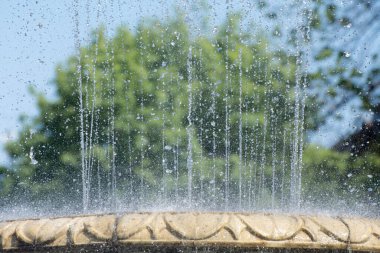 Şehir parkındaki su püskürtüleri ve çeşme spreyi. Su damlalarından alınan arkaplan.