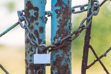 Eski bir asma kilit paslı kapıyı kapattı..