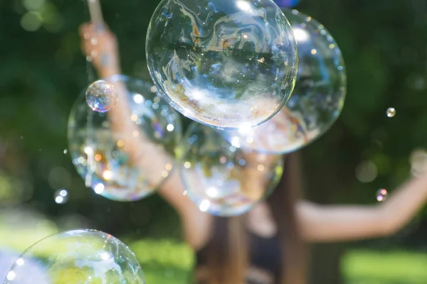 Big bubbles are flying in the air. Show and entertainment for children. Beautiful background for design.