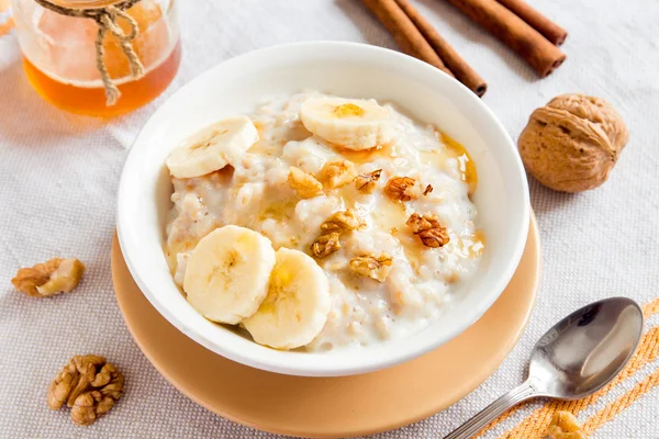 Oatmeal porridge with banana, nuts and honey — Stock Photo, Image