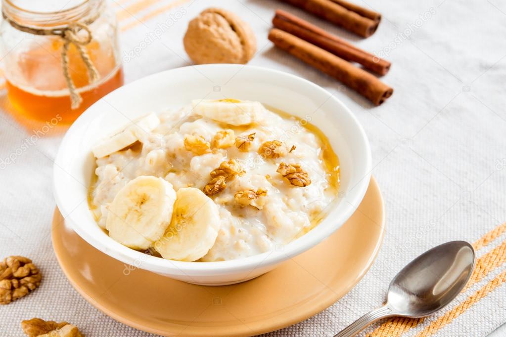 Oatmeal porridge with banana, nuts and honey Stock Photo by ©Mizina