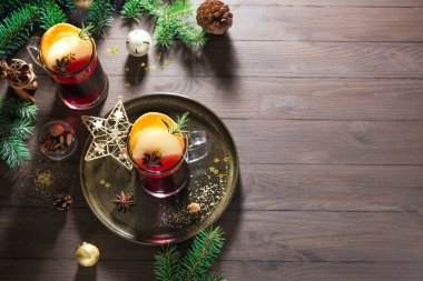 Noel baharatlı, elmalı ve portakallı kırmızı şarap ahşap kırsal masa üzerinde, kopyalama alanı. Noel ve kış tatilleri için geleneksel sıcak içecek..