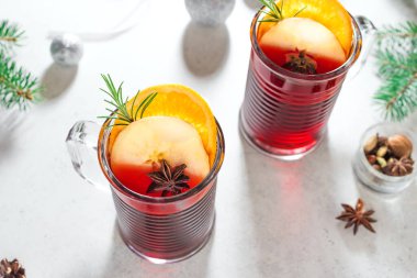 Noel arkaplanda baharat, elma ve portakallı kırmızı şarap. Noel ve kış tatilleri için geleneksel sıcak içecek..