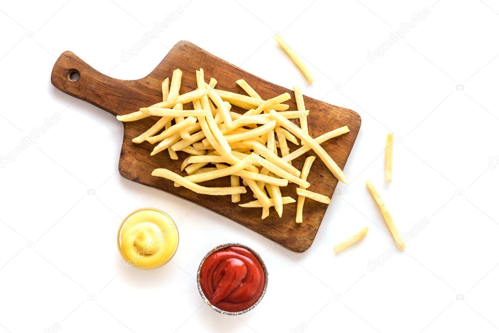French fries on board with ketchup and cheese sauce isolated on white background. Homemade french fries.