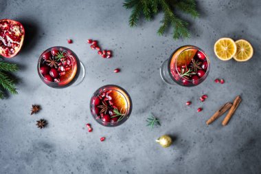 Kış Kırmızı Şarap Sangria. Kızılcık, nar, portakal, biberiye ile Noel kokteyli gri taş masa, üst manzara, kopyalama alanı.