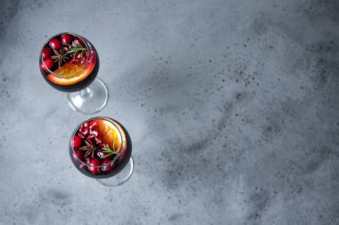 Kış Kırmızı Şarap Sangria. Kızılcık, nar, portakal, biberiye ile Noel kokteyli gri taş masa, üst manzara, kopyalama alanı.
