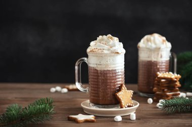 Kışın sıcak kahve ve zencefilli kurabiye. Noel kurabiyeleri ve kupalar dolusu sıcak çikolata ahşap masada, kopyalama alanı.
