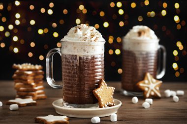 Kışın sıcak kahve ve zencefilli kurabiye. Noel kurabiyeleri ve kupalar dolusu sıcak çikolata ahşap masada, kopyalama alanı.